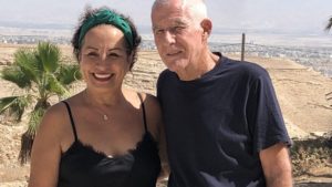 Lital and Zohar Aizenberg smile at their Mi Casa Tu Casa bed and breakfast in Moshav Vered Yericho, with the city of Jericho in the background, Sept. 29, 2022. Credit: Josh Hasten.