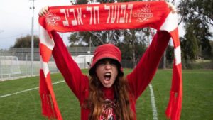 Superfan Amit Kaminsky holds aloft the colors of Hapoel Tel Aviv F.C. Courtesy.